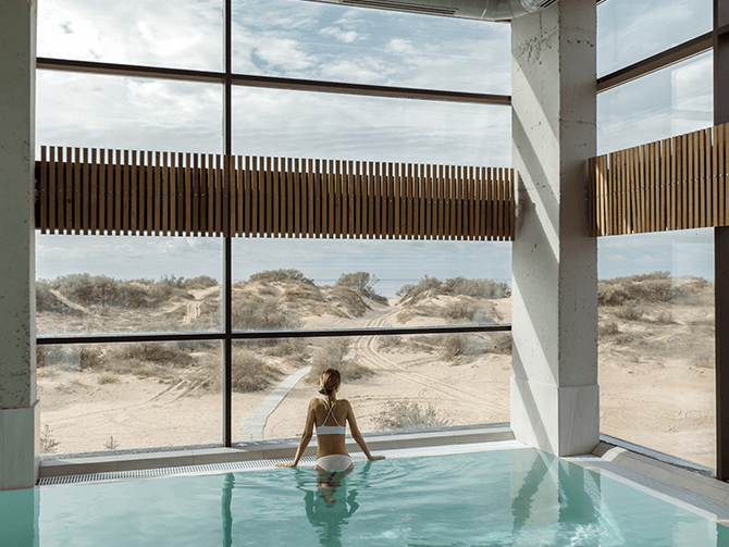 Eine Frau im Pool schaut aus dem Fenster